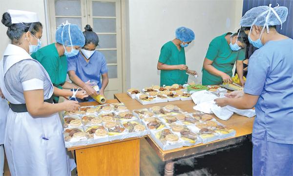 අලුත් අවුරුද්ද නිමිත්තෙන් කොළඹ මුල්ලේරියාව, අයි.ඩී.එච් රෝහලේ නිරෝධානය වන කොවිඩ් රෝගීන් වෙනුවෙන් එම රෝහලේ අධ්යක්ෂ, වෛද්ය, හෙද ඇතුළු සියලුම කාර්ය මණ්ඩලය එක්වී කැවුම්, කිරිබත් ඇතුළු සියලුම කැවිලි වර්ග ඇතුළත් ආහාර පාර්සලයක් ලබාදීමට කටයුතු කළහ. ඒ සඳහා රෝහල් කාර්යමණ්ඩලය යුහුසුළුව සුදානම් වූයේ මෙලෙසිනි. ඡායාරූපය- සුලෝචන ගමගේ