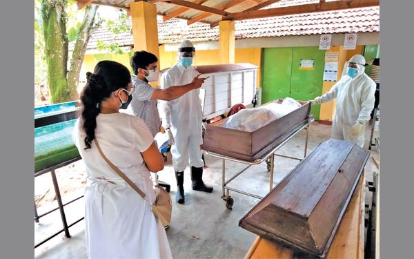 පවුලේ ඥාතීන් දෙදෙනෙකුට පමණක් මුද්රිත පොලිතීන් බෑගයේ දැමූ කොරෝනා මළ සිරුරක් මොහොතකට විවෘත කර පෙන්වන අයුරු