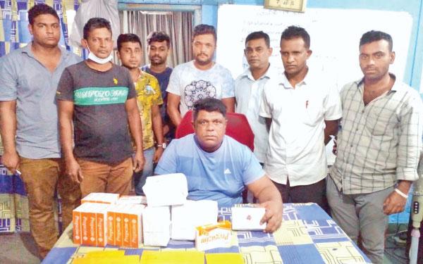 වැටලීම සිදුකළ මහනුවර කොට්ඨාස දූෂණ මර්දන අංශයේ නිලධාරීන් අත්අඩංගුවට ගත් මත්පෙති තොගය සමඟ