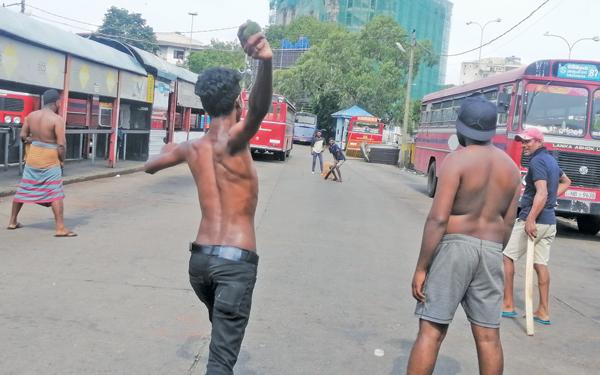 තරුණයන් පිටකොටුව බස් නැවතුමේ ක්රිකට් ක්රීඩා කරමින්
