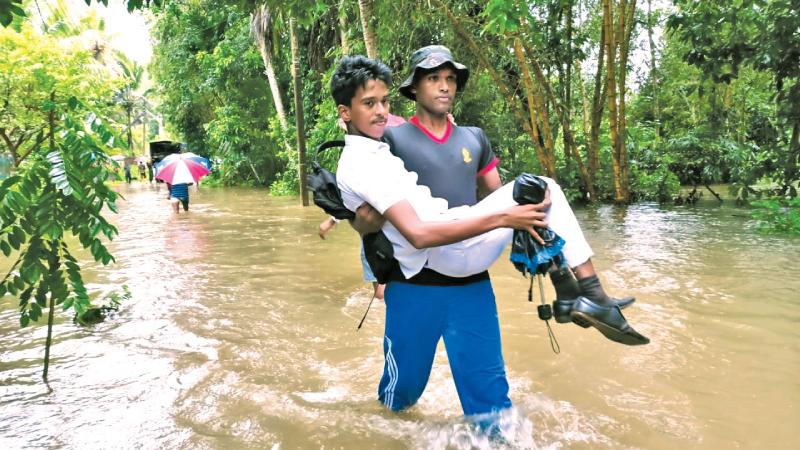 පැලවත්ත හමුදා කඳවුරේ සෙබළෙක්   සා. පෙළ සිසුවකු ගංවතුරේ ඔසවාගෙන යමින්