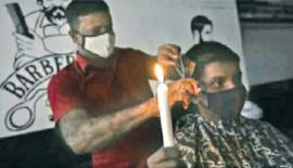 විදු­ලිය ඇණ හිටීම නිසා ඉටි­ප­න්දම් එළි­යෙන් කොණ්ඩය කපන කර­ණ­වෑ­මි­යෙක්   (සේයා­රුව - අන්ත­ර්ජා­ල­යෙනි)