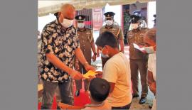පොලි­ස්පති සී. ඩී. වික්‍ර­ම­රත්න මහතා දරු­වන් දෙදෙනා ට  මූල්‍ය පරි­ත්‍යාග කරන අයුරු