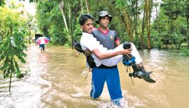 පැලවත්ත හමුදා කඳවුරේ සෙබළෙක්   සා. පෙළ සිසුවකු ගංවතුරේ ඔසවාගෙන යමින්